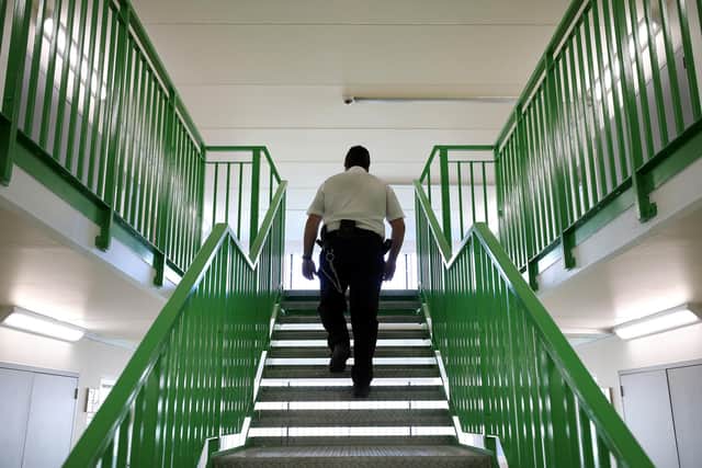 A prison guard walks through a cell area. Picture: Dan Kitwood/Getty Images