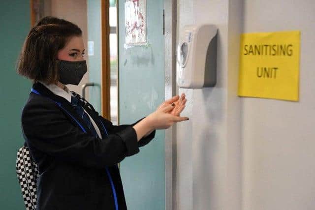 A pupil at a school in Scotland using a hand sanitiser station as schools reopened after lockdown picture: JPI Media