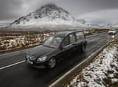 The funeral cortege of Dr Hamish MacInnesmakes its way past Buachaille Etive Mor in Glencoe