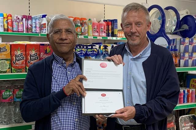 Postmaster Iqbal Mohammed receiving Post Office 30 Years' Long Service Award from Area Manager Brian McNaughton