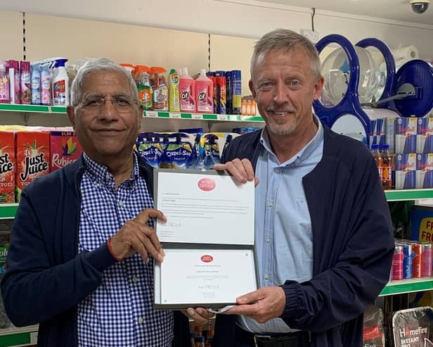 Postmaster Iqbal Mohammed receiving Post Office 30 Years' Long Service Award from Area Manager Brian McNaughton