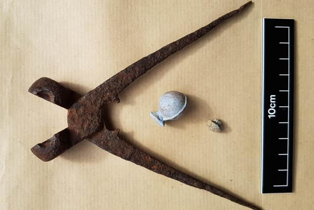 Iron mould for making lead shot, moulded impression of a shot from it and a snipped-off lead sprue similar to the one found at Glensheil (National Trust for Scotland)