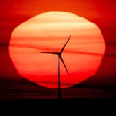 The sun rises behind a wind turbine. Up to 80 jobs will be made redundant at SGL Carbon, which makes the material used for wind turbines, amid a downturn in the sector. Picture: AP Photo/Michael Probst