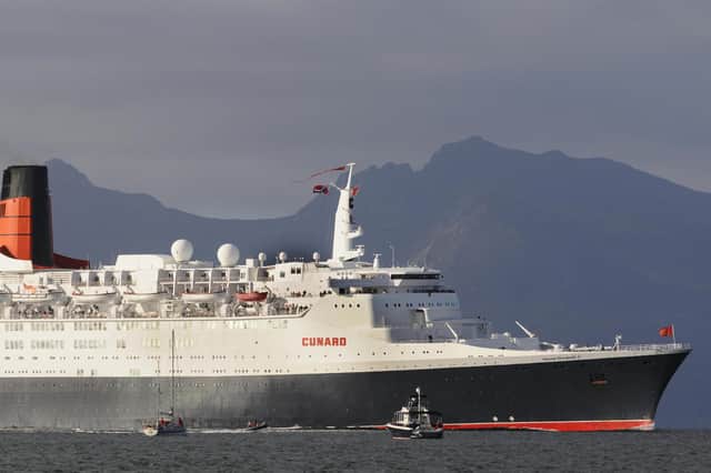 The Clyde-built Queen Elizabeth 2 cruise liner sails past Arran in 2008 before making its final journey to become a luxury floating hotel in Dubai (Picture: Paul Barker/AFP via Getty Images)