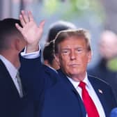 Former US President Donald Trump waves as he departs Trump Tower for Manhattan Criminal Court