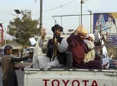 Taliban fighters wave from the back of a pickup truck, in Kabul, Afghanistan, Monday, August 30