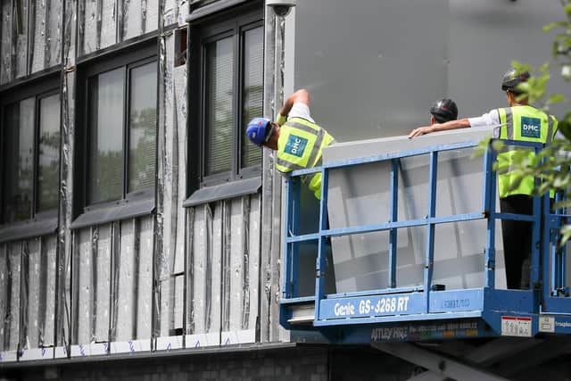 Workers remove cladding for testing from a tower block in the wake of the Grenfell Tower tragedy. Picture: Christopher Furlong/Getty Images