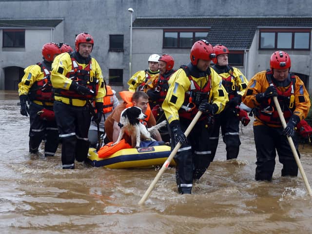 Members of the coastguard rescue team wade through flood waters to evacuate a man and a dog in Brechin on October 20 after areas close to the river were overwhelmed by water which breached flood defences. Picture: Jeff J Mitchell/Getty Images