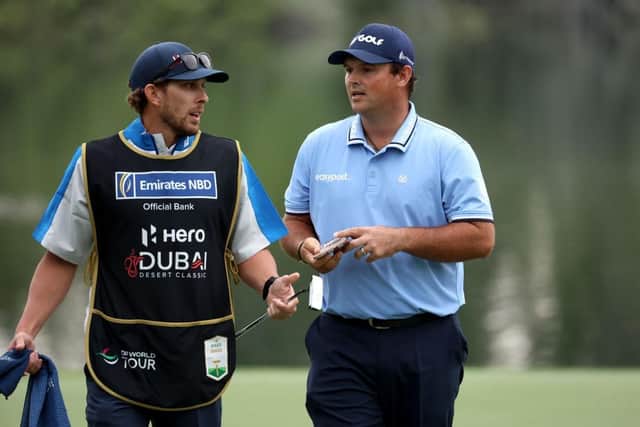 Patrick Reed speaks with his caddie during the opening round of the Hero Dubai Desert Classic at Emirates Golf Club. Picture: Warren Little/Getty Images.