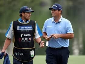 Patrick Reed speaks with his caddie during the opening round of the Hero Dubai Desert Classic at Emirates Golf Club. Picture: Warren Little/Getty Images.