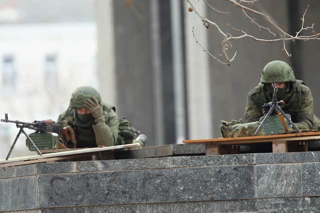 Soldiers without identifying insignia outside the Crimean parliament building in Simferopol, Ukraine, in 2014, shortly before Russia annexed the region (Picture: Sean Gallup/Getty Images)