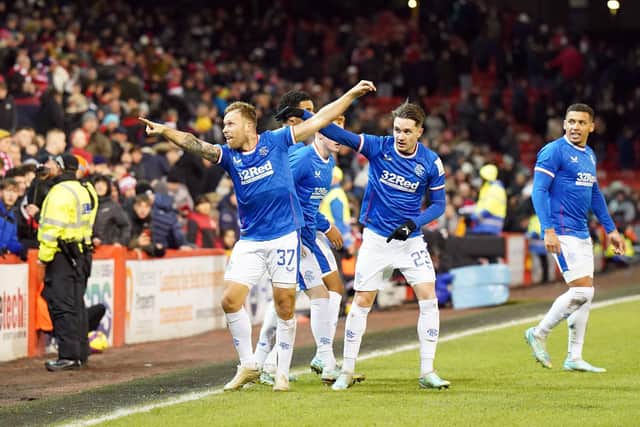Scott Arfield leads the celebrations with the Rangers fans after scoring a 97th-minute winner at Pittodrie.