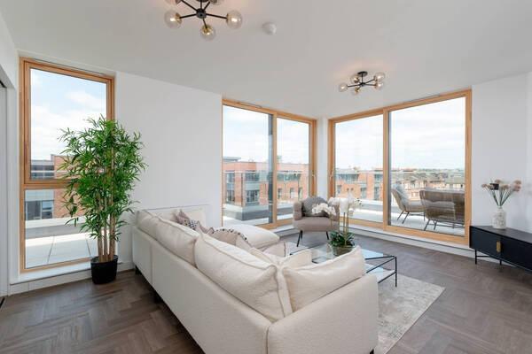Interior: Private fob key lift access leads directly to the property with open-plan living/dining/kitchen area with sliding doors to the outdoor space. The third bedroom could be an office.