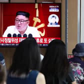 People watch a television broadcast showing a file image of North Korean leader Kim Jong-Un at his government's attempt to launch a spy satellite last month.