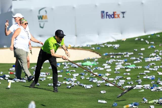 Groundskeepers sweep up bottles and cans thrown from the stands on the 16th hole after a hole-in-one by Sam Ryder during the third round of the WM Phoenix Open at TPC Scottsdale Arizona. Picture: Mike Mulholland/Getty Images.