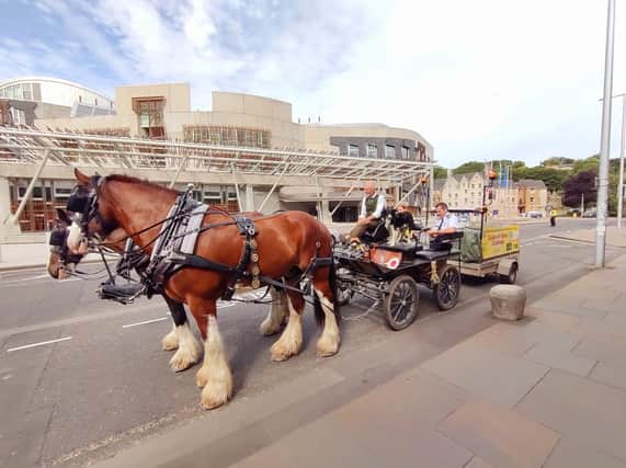 Mr Alcock passes the Scottish parliament during the charity challenge