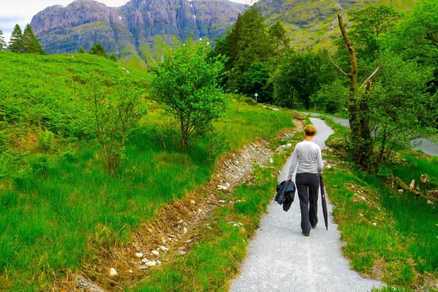 A woman walking on a narrow foot path toward the mountains of Glencoe, Highlands - a popular destination with tourists and locals alike (pic: Getty Images/iStockphoto)