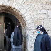 Nuns, mask-clad due to the Covid-19 pandemic, enter the Church of the Nativity on Christmas Day