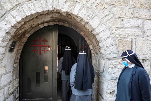 Nuns, mask-clad due to the Covid-19 pandemic, enter the Church of the Nativity on Christmas Day