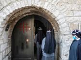 Nuns, mask-clad due to the Covid-19 pandemic, enter the Church of the Nativity on Christmas Day