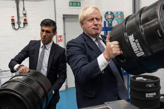 British Prime Minister Boris Johnson (R) and Britain's Chancellor of the Exchequer Rishi Sunak (L) carry barrels as they visit Fourpure Brewery in Bermondsey, London. Picture: by Dan Kitwood/Getty Images