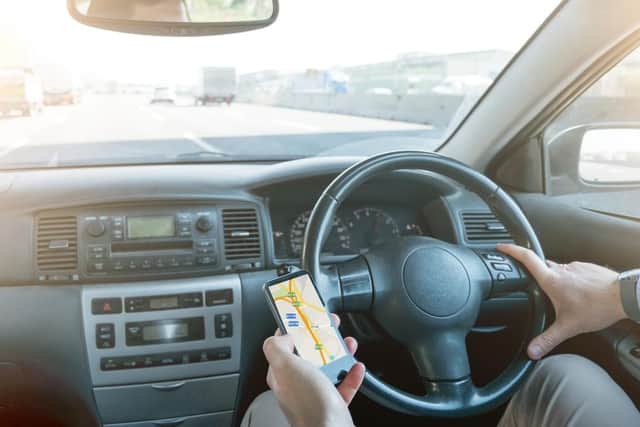 Using a handheld phone while driving is illegal