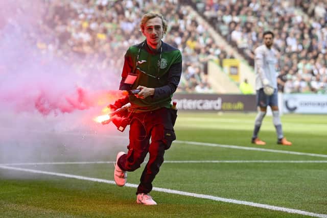 A flare is removed from the pitch during the Edinburgh derby between Hibs and Hearts at Easter Road on Sunday. (Photo by Rob Casey / SNS Group)