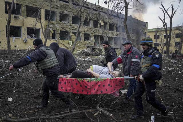 Ukrainian emergency employees and volunteers carry a fatally injured pregnant woman from a maternity hospital hit by shelling in Mariupol, Ukraine (Picture: Evgeniy Maloletka/AP)