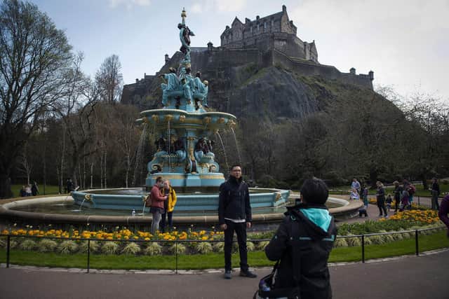 Tourists take photographs in front of the newly-restored Ross Fountain in Princes Street gardens in Edinburgh. Photo: Andy Buchanan