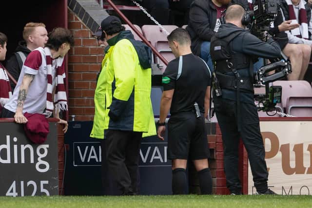 Referee Nick Walsh stops play to consult VAR over a possible red card for Hearts' Alex Cochrane.