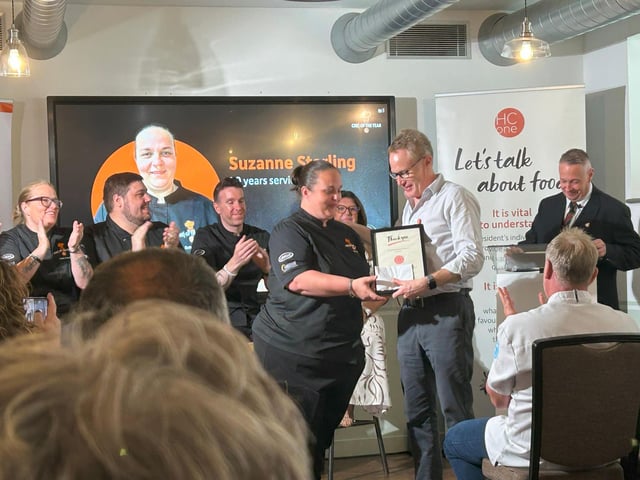 Suzanne Stirling, Group Development Chef at HC-One being presented with her 20 year long service award by James Tugendhat, Chief Executive Officer at HC-One at the HC-One Chef of the Year Competition 2025
