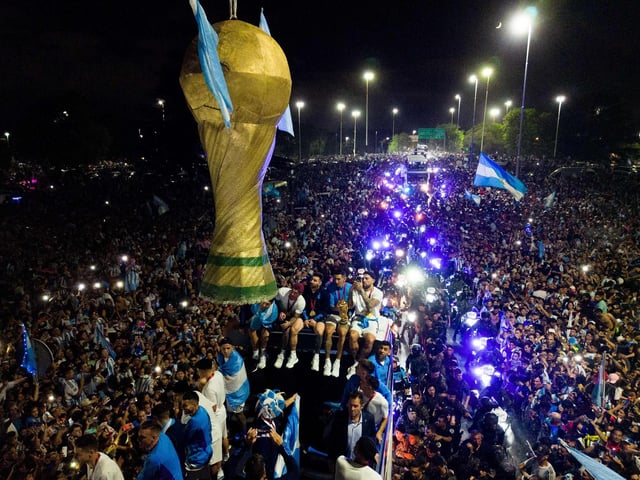 The bus moved at a snail’s pace as fans, many of whom were waving Argentine flags, swarmed towards it, eager for a glimpse of the players as law enforcement officers tried to keep them at bay.