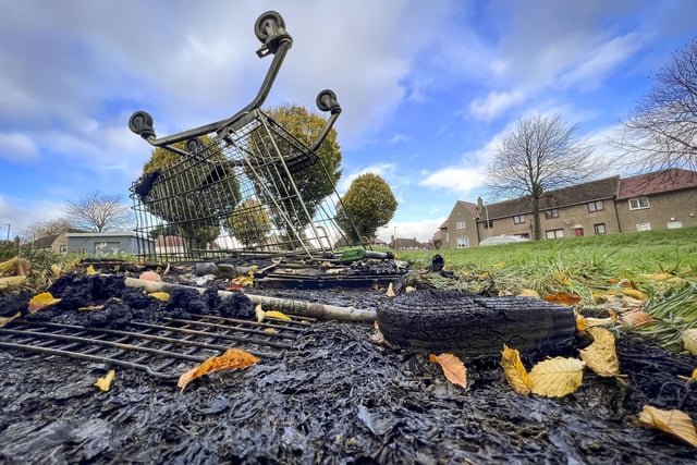 A supermarket trolley on top of an extinguished fire following a night of disorder.