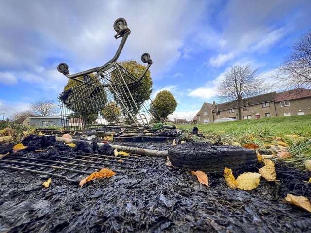 A supermarket trolley on top of an extinguished fire following a night of disorder.
