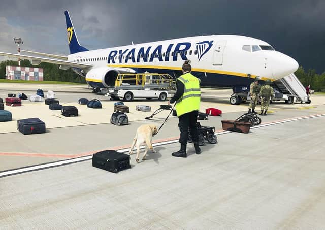 Security forces check the luggage of passengers on the Ryanair plane that was carrying opposition figure Raman Pratasevich from Athens to Vilnius, until it was forced to land at Minsk international airport (Picture: Onliner.by via AP)
