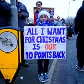 An Everton fan holds up a sign in protest of the club's point deduction.