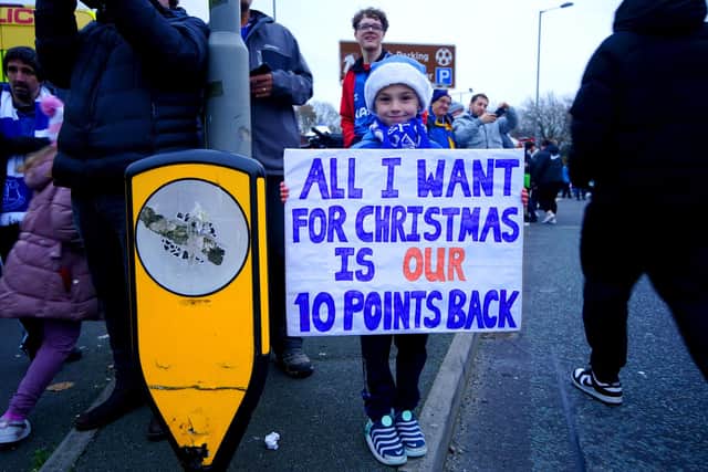 An Everton fan holds up a sign in protest of the club's point deduction.