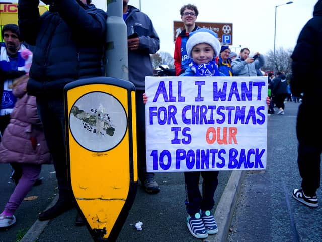 An Everton fan holds up a sign in protest of the club's point deduction.