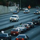Motorists stop and wave as police cars pursue a white Ford Bronco, driven by Al Cowlings, carrying fugitive murder suspect OJ Simpson, during a 90-minute, slow-speed car chase in Los Angeles in 1994 (Picture: Jean-Marc Giboux/Liaison/Getty Images)