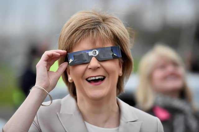 Nicola Sturgeon uses protective glasses to look at a partial solar eclipse (Picture: Jeff J Mitchell/Getty Images)