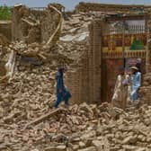 Villagers along with rescue workers examine the extent of damage at a village following an earthquake in Bernal district, Paktika province,which killed at least 1,000 people and left thousands more homeless.