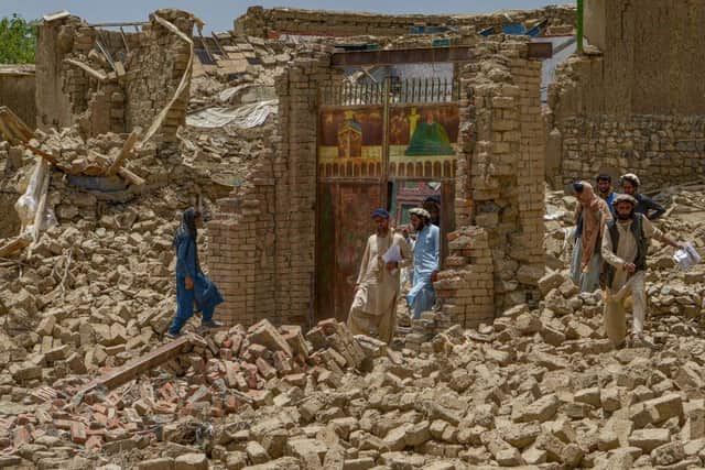 Villagers along with rescue workers examine the extent of damage at a village following an earthquake in Bernal district, Paktika province,which killed at least 1,000 people and left thousands more homeless.