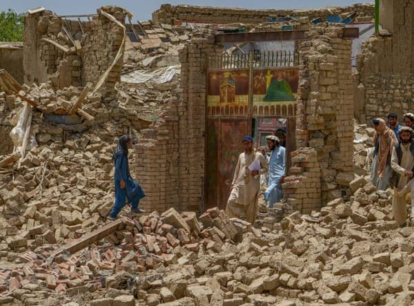 Villagers along with rescue workers examine the extent of damage at a village following an earthquake in Bernal district, Paktika province,which killed at least 1,000 people and left thousands more homeless.
