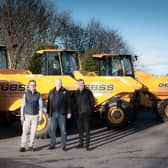 Bart Kulej, George Burns, and David Owens are pictured beside the new fleet of dumpers.