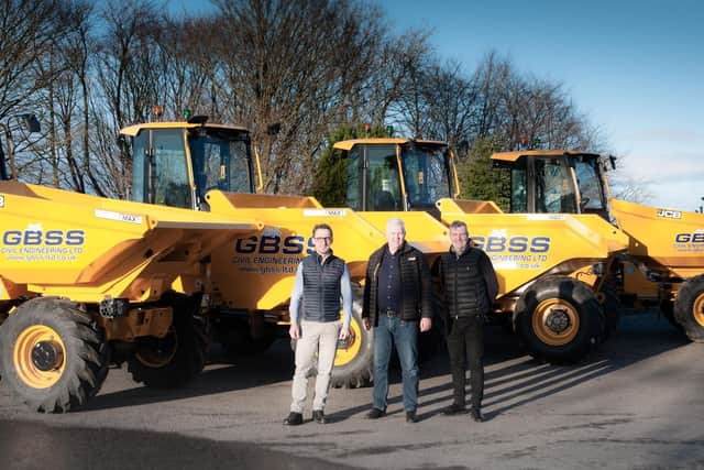 Bart Kulej, George Burns, and David Owens are pictured beside the new fleet of dumpers.