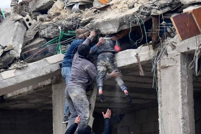 Locals in Jandaris (Syria) rescue an injured girl from the debris of a building destroyed by a major earthquake.