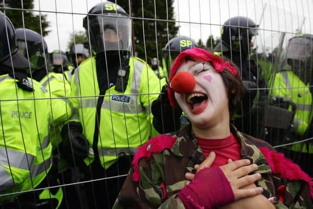 A protester dressed as a clown stands by a fence near the Gleneagles hotel during the 2005 G8 summit.
