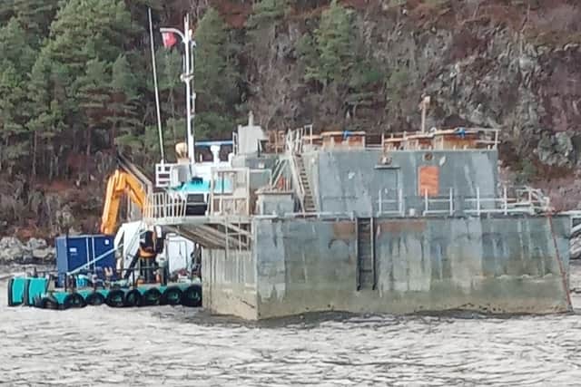 The feed barge has been run aground in Loch Reraig, part of the Loch Carron marine protected area, to allow removal of remaining rotten food