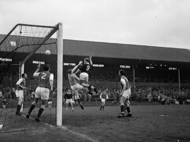 Keeper Willie Wilson and Hibs teammates mob the goalmouth as Hearts' Tommy White comes in for the attack during the Edinburgh Derby in May 1964.