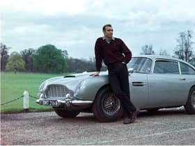 Edinburgh-born actor Sean Connery poses beside the Aston Martin DB5 in a publicity shot for the James Bond film Goldfinger.